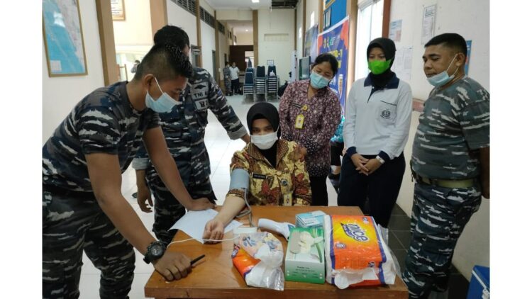 PEMERIKSAAN— Seorang tenaga kesehatan (nakes) Pangkalan Utama Angkatan Laut (Lantamal) II Padang sedang pemeriksaan tensi sebelum mendapatkan suntik vaksin tahap III.