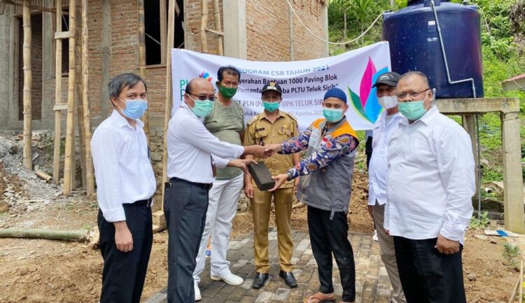 SERAHKAN—Peduli: Manager PLN UPK Teluk Sirih, Mustika Efendi menyerahkan paving blok kepada Lurah Teluk Kabung Tengah, Nasril Doni Eka Putra untuk kelanjutan pembangunan mushala Al-Kautsar, kemarin.