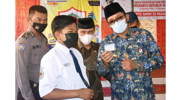 PERLIHATKAN KARTU VAKSIN— Wako Padang Hendri Septa bersama seorang pelajar SMP memperlihatkan kartu vaksinasi saat meninjau pelaksanaan vaksinasi di SMPN 33, Kamis (9/9).