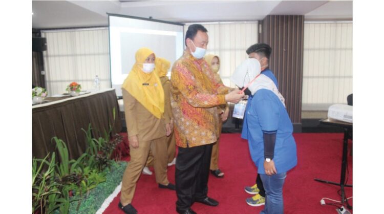 KALUNGKAN  TANDA PESERTA— Anggota DPRD Sumbar Dodi Delvi mengalungkan kokarde peserta pelatihan Digital Marketing di Hotel Grand Rocky Bukittinggi.