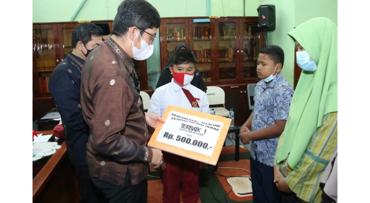 PENYERHAAN HADIAH— Wali Kota Sawahlunto Deri Asta menyerahkan hadiah kepada para pengunjung teladan Perpustakaan Umum Adinegoro.