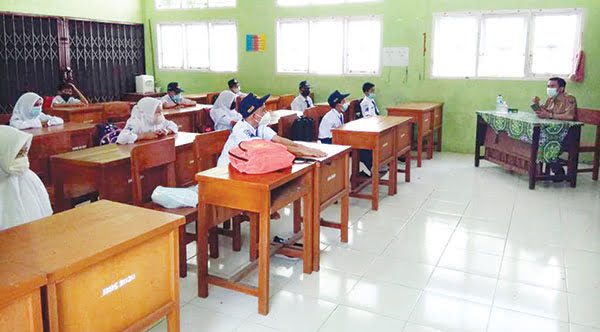 PTM DI SMPN 21— Pembelajaran Tatap Muka (PTM) di SMPN 21 Padang, kemarin berlangsung aman dengan penerapan protokol kesehatan. Siswa yang boleh belajar di sekolah sudah divaksin, sedangkan yang belum divaksin tetap belajar di rumah.