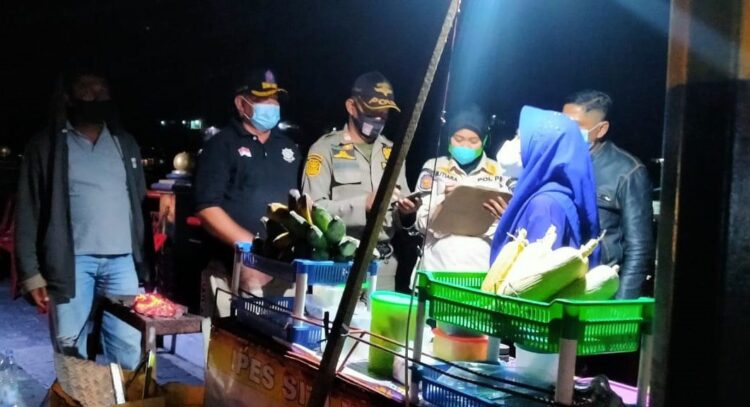 SERAHKAN SURAT Petugas Satpol PP Kota Padang menyerahkan surat panggilan kepada seluruh PKL yang berjualan di kawasan Jembatan Siti Nurbaya, Rabu (27/10) malam.