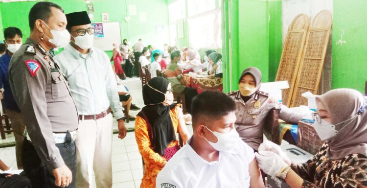 VAKSINASI GOES TO SCHOOL— Para pelajar MTsN 2 Padang dan masyarakat di sekitar sekolah antusias mengikuti vaksinasi bertajuk ”Gebyar Vaksin Badunsanak Goes to School” yang digelar Polresta Padang, Jumat (8/10).