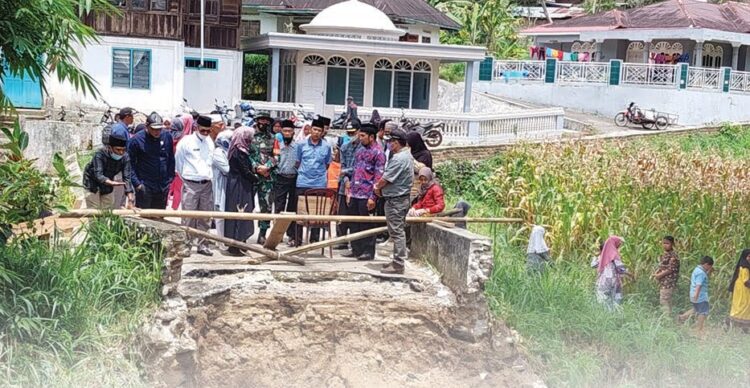 TINJAU JEMBATAN— Ketua Komisi lll DPRD Agam meninjau jembatan yang ambruk dihantam bencana banjir beberapa waktu lalu.