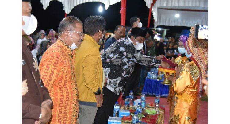 DISAMBUT--Bupati Padangpariaman Suhatri Bur saat disambut dengan sirih dalam caroano ketika acara pembukaan open tournamen sepak bola Pelajar Sungai Geringging.