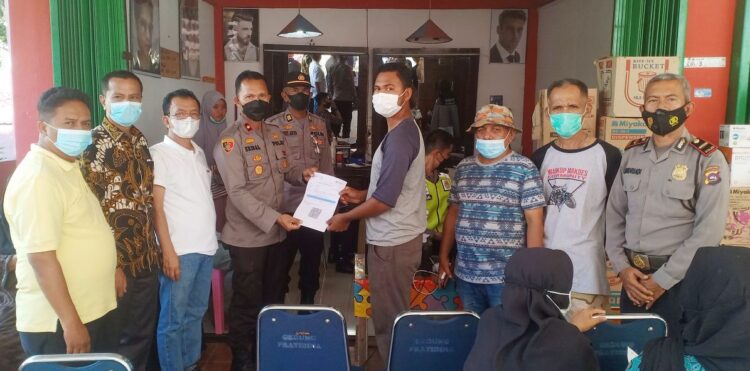 SERAHKAN—Wakapolres Kompol Eridal didampingi Khairul Abdi, Agus Tofik serta tokoh masyarakat serahkan sertifikat vaksin pada masyarakat.