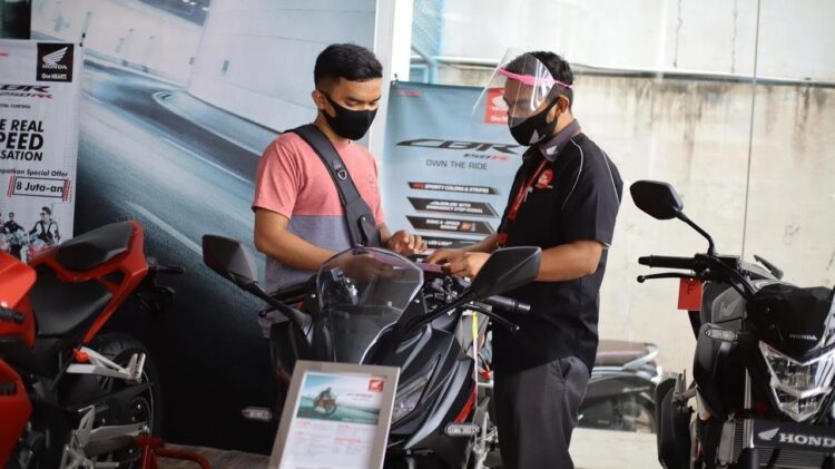 BERIKAN PENJELASAN-Sales marketing PT Menara Agung menjelaskan fitur-fitur serta kelebihan yang disematkan di New Honda CBR150R kepada konsumen.