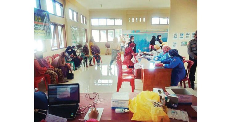 VAKSINASI KELURAHAN — Warga Kelurahan Tanah Sirah mendatangi unit layanan kesehatan untuk mendapatkan vaksin dosis I dan II.