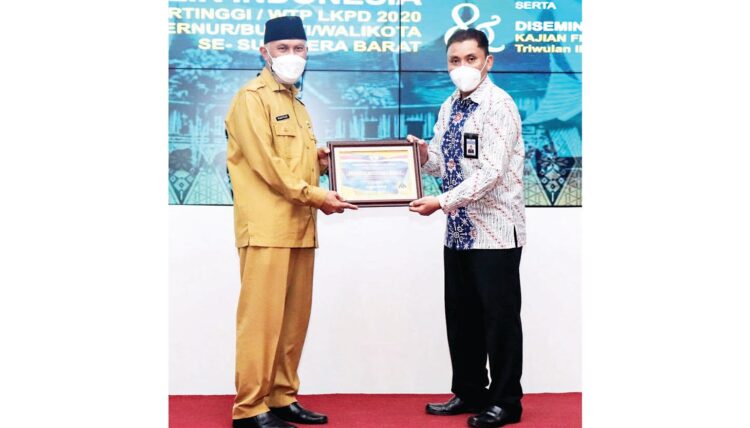 TERIMA PENGHARGAAN— Plakat dan piagam Opini WTP diterima langsung oleh Gubernur Sumbar, Mahyeldi Ansharullah dari Kepala Kantor DJPb Wilayah Sumbar, Heru Pudyo Nugroho, di Auditorium Gubernuran, Senin (25/10).