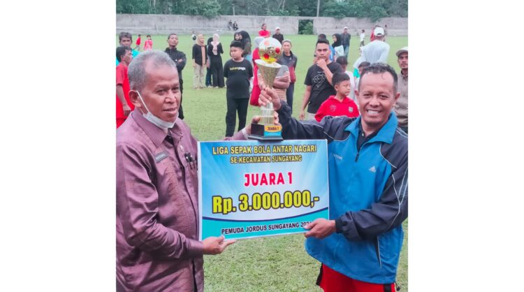 Turnamen Antar Nagari U-37, Tim Super Minangkabau Gondol Trofi Juara 1 SERAHKAN HADIAH— Kadis PMDPPKB Novenril menyerahkan tropi bergilir serta uang tunai untuk pembinaan kepada kapten Chandra Antoni.