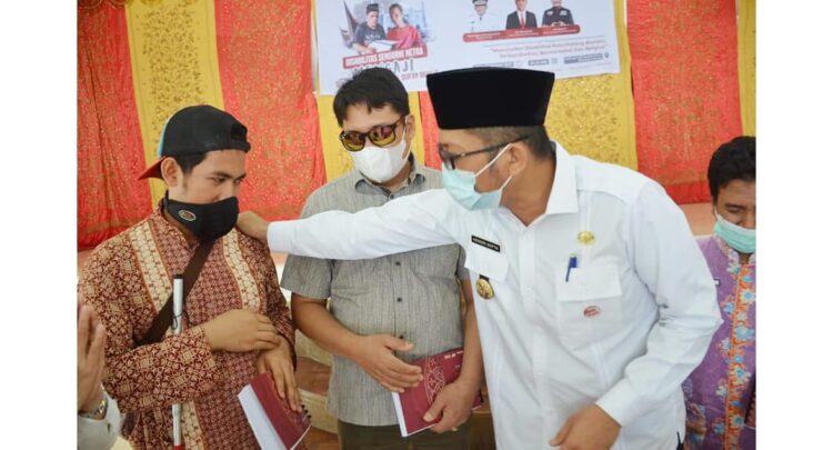 WAQAF AL QURAN BRAILLE— Wako Hendri Septa menyerahkan bantuan wakaf berupa Al Quran Braille kepada 60 orang penyandang disabilitas netra di Palanta Kediaman Resmi Wali Kota Padang, Rabu (27/10) pagi.