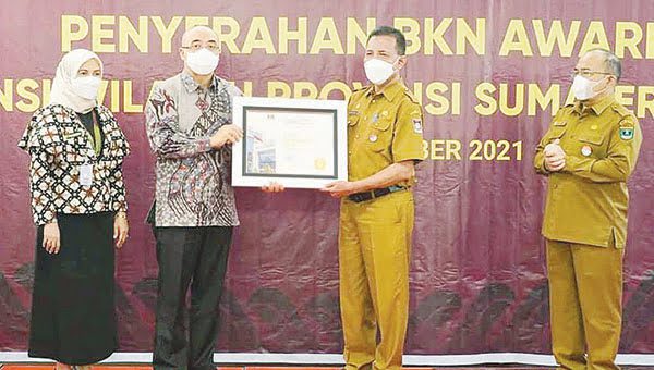 BKN AWARD 2021— Pj Sekda Kota Padang Arfian menerima penghargaan BKN Award 2021 yang diserahkan Plt Kepala Badan Kepegawaian Nasional (BKN) Bima Haria Wibisana dalam ajang Anugerah BKN Award 2021 di Hotel Grand Zuri Padang, Senin (18/10).