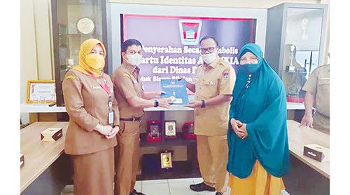 PENYERAHAN KIA— Plt Kepala Disdukcapil Kota Padang Didi Aryadi menuerahkan secara simbolis Kartu Identitas Anak (KIA) bagi peserta didik tingkat SD dan SMP kepada Sekretaris Dinas Pendidikan dan Kebudayaan (Disdikbud) Danti Arvan, Selasa (12/10).