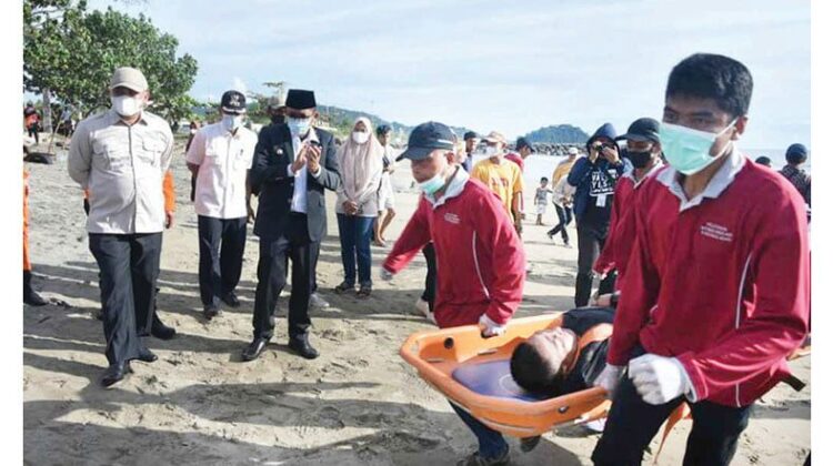 SIMULASI PENYELAMATAN—  Wako Padang Hendri Septa menyaksikan simulasi penyelamatan pertolongan korban di pantai serta memasang tanda larangan berenang, sekaligus menutup pelatihan mitigasi bencana di kawasan Pantai Cimpago, Kamis (28/10).