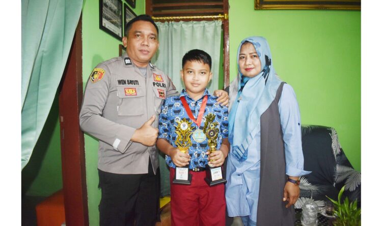 PEGANG—Abigail Barca Bagaskara, pelajar SD 3 Pertiwi Padang memegang piala berprestasi tingkat nasional didampingi kedua orang tua, Aiptu Wen Sayuti dan Wenni Primayuni, SE.