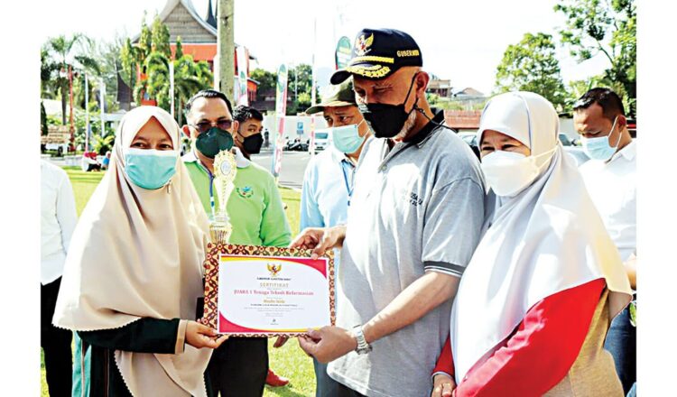 SERAHKAN— Gubernur Sumbar, Mahyeldi Ansharullah didampingi Ketua TP PKK Sumbar, Harneli Mahyeldi menyerahkan piala dan piagam kepada pemenang lomba kesehatan.
