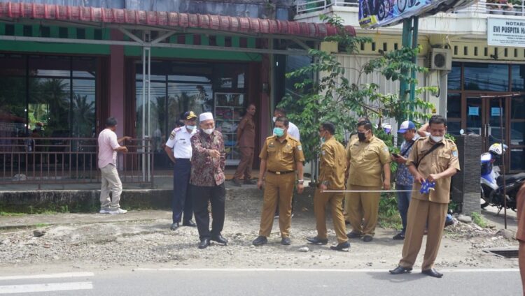 PELEBARAN JALAN— Bupati Pasbar Hamsuardi  sedang mengawasi petugas Dinas Pekerjaan Umum saat pengukuran pelebaran jalan.