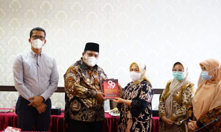 SERAHKAN—Bupati Padangapriaman Suhatri Bur serahkan    cendra mata kepada Deputi Dukcapil.