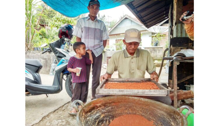 BUAT GULA SEMUT— Madi, saat membuat gula semut disaksikan Manik.