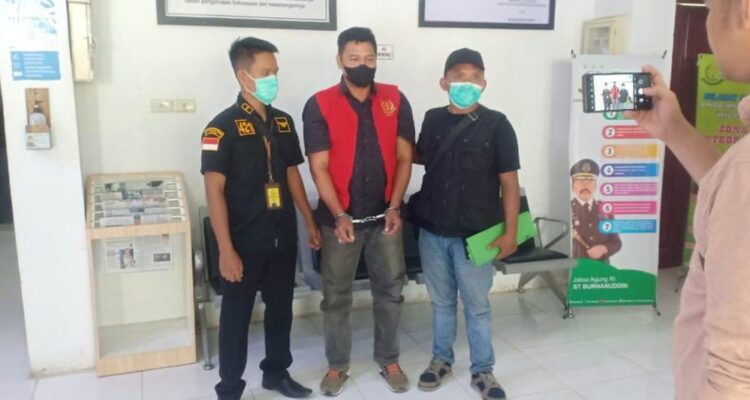 DIAMANKAN— Tersangka Sufnizar alias Babang (49) yang merupakan mantan Kepala Cabang PT. Muda Mandiri Sejahtera Cabang Lubuk Sikaping (tengah) memakai baju rompi merah, telah berhasil diamankan oleh pihak Kejaksaan di Provinsi Aceh.