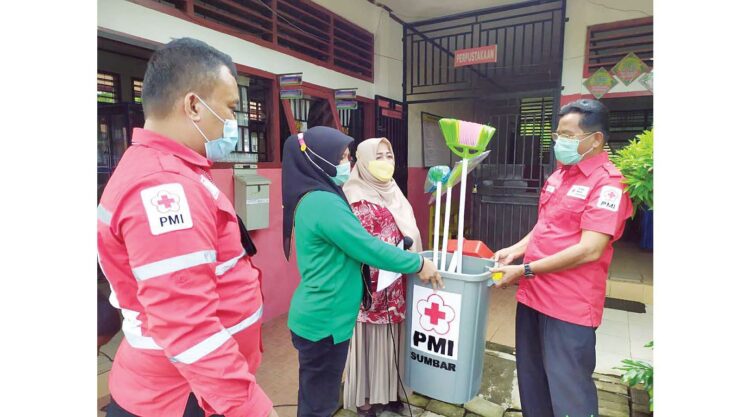 ALAT KEBERSIHAN— Ketua PMI Sumbar, Aristo Munandar menyerahkan bantuan paket peralatan kebersihan di SDN 13 Sungai Pisang sekaligus melakukan Aksi Bersih Sekolah.