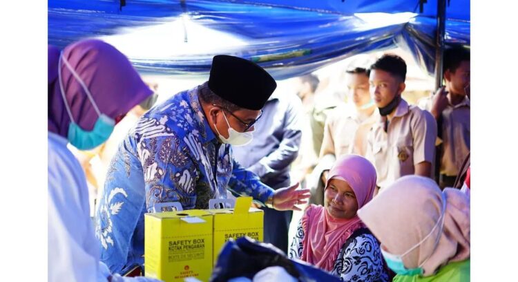 Pemkab Padangpariaman Targetkan 6.358 Warga Ikut Vaksin Perhari 1 DIALOG—Suhatri Bur saat dialog dengan seorang warga yang akan disuntik vaksin.