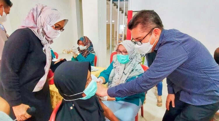 SUNTIK VAKSIN—Kadis Kesehatan Yutiardy Riva’i  saat suntik warga yang divaksin.