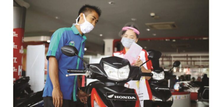 LAYANI KONSUMEN-Sales Marketing Menara Agung tengah melayani konsumen saat pembelian Honda Supra GTR 150.