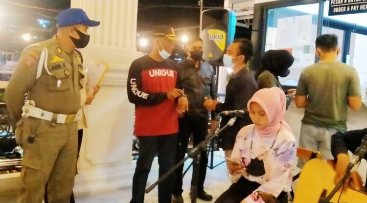 DATANGI KAFE— Petugas Satpol PP Kota Padang mendatangi sejumlah kafe di kawasan Batang Arau dan Permindo, Sabtu (20/11) malam. Pemilik kafe diingatkan untuk tetap mematuhi prokes dan Perda AKB serta menyediakan aplikasi Peduli Lindungi.