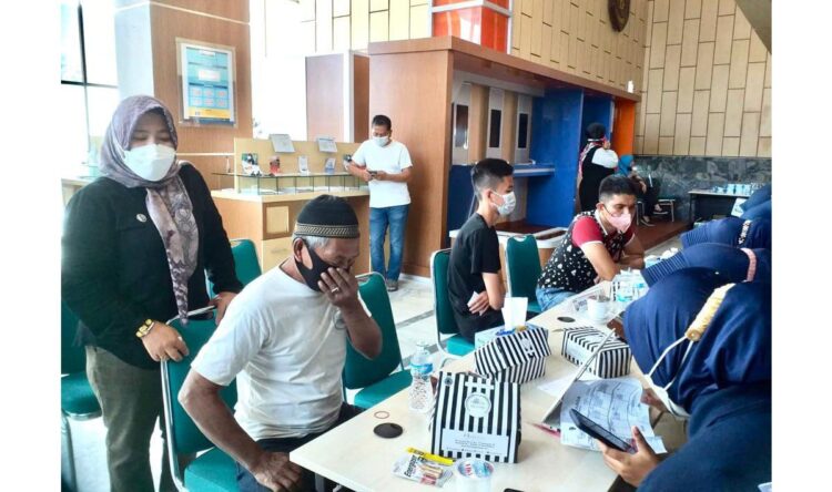 PERIKSA KESEHATAN— Petugas memeriksa semua peserta yang akan mengikuti vaksinasi di Kantor Bank Nagari di Jalan Pemuda Padang, Sabtu (20/11).