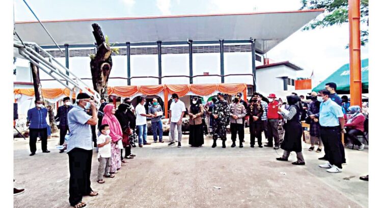 SERAHKAN HADIAH— Wali Kota H Riza Falepi ketika menyerahkan hadiah kepada warga yang ikut vaksinasi di GOR Kubu Gadang.