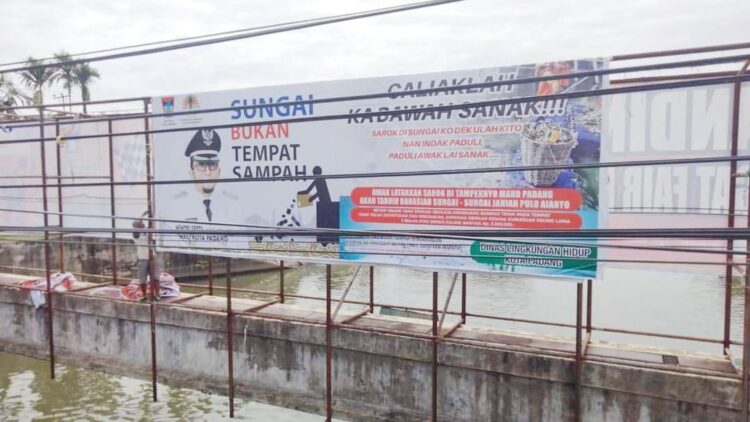 BALIHO DI BANJIR KANAL—  DLH Kota Padang memasang baliho imbauan di Banjir Kanal GOR H Agus Salim, meminta warga untuk tidak membuang sampah sembarangan.