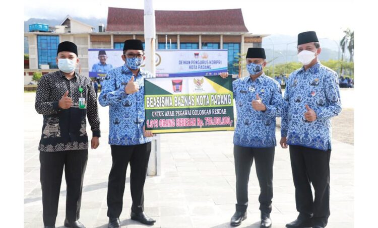 UPACARA HUT KORPRI— Wali Kota Padang Hendri Septa menyerahkan secara simbolis beasiswa untuk anak pegawai golongan rendah sebanyak 1.019 orang sebesar Rp750 juta, saat peringatan HUT ke-50 tahun Korpri di Lapangan Kantor Balaikota Padang, Aie Pacah, Senin pagi (29/11).