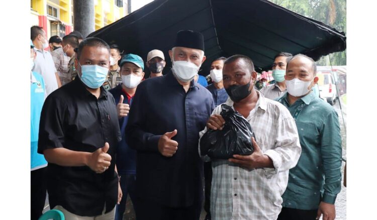 Gebyar Sumdarsin di Halaman Kantor Gubernur Diikuti Ribuan Warga, Optimis Target 70 Persen Vaksinasi di Sumbar Tercapai 1 DAMPINGI—Gubernur Sumbar, Mahyeldi Ansharullah didampingi, Sekdaprov Sumbar, Hansastri dan Kepala Dinkes Sumbar, Arry Yuswandi memberikan sembako kepada peserta vaksin di Halaman Kantor Gubernur, Sabtu (18/12).