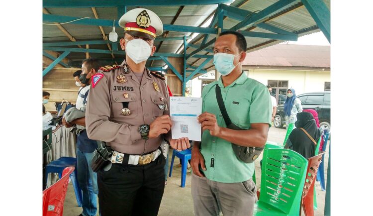 Antisipasi Omicron Masuk Sumbar, Kartu Vaksin Pengendara Sumbar-Riau Diperiksa 1 SERAHKAN KARTU VAKSIN— Kasat Lantas Polres Limapuluh Kota Iptu Dian Jumes Putra saat memberikan sertifikat vaksin salah seorang pengendara di Mapolres Limapuluh Kota