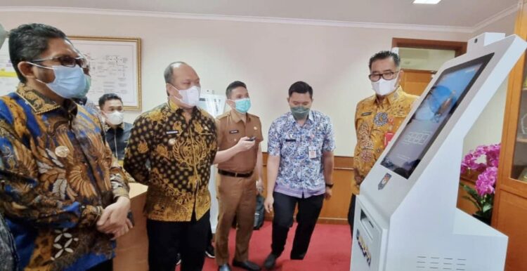 ANJUNGAN SIMUDAH—  Mesin Anjungan Simudah diterima Wako Padang Hendri Septa dari Ditjen Otda Akmal Malik, Selasa (7/12).