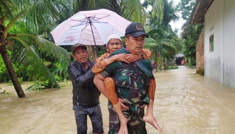 Babinsa Bantu Warga Terdampak Banjir di Korong Baruh 1 EVAKUASI—Sertu Erry Babinsa Koramil 07/Pauh Kamba saat mengevakuasi warga yang terkena banjir, Sabtu (18/12) di Kampuang Galapuang.