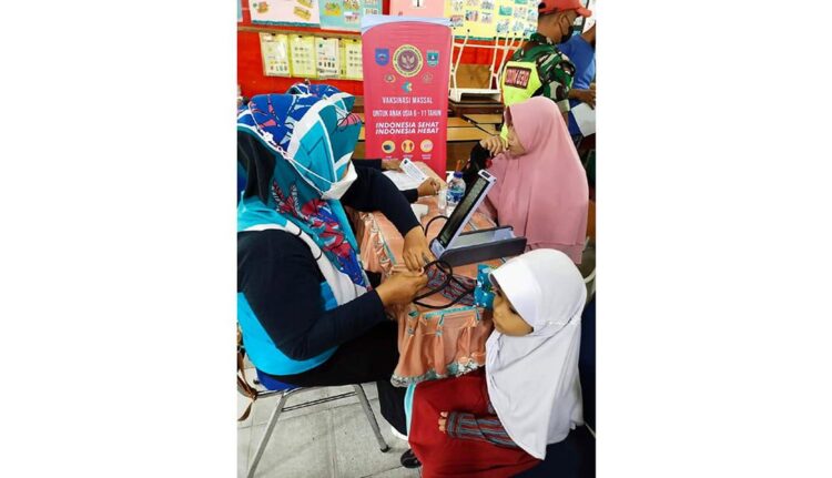 SUNTIK VAKSIN ANAK— Terlihat pelajar SD saat menunggu giliran suntik vaksin yang diinisiasi oleh BINDA Sumbar, Senin (27/12).