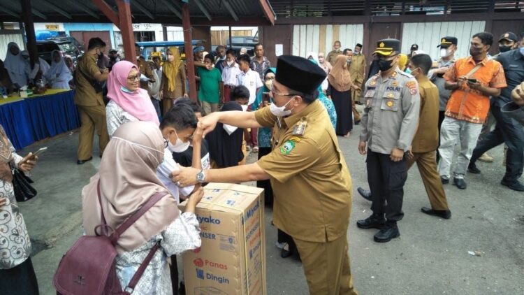 SERAHKAN HADIAH—Bupati Pasaman Benny Utama saat menyerahkan hadiah doorprize gebyar vaksinasi kepada peserta.
