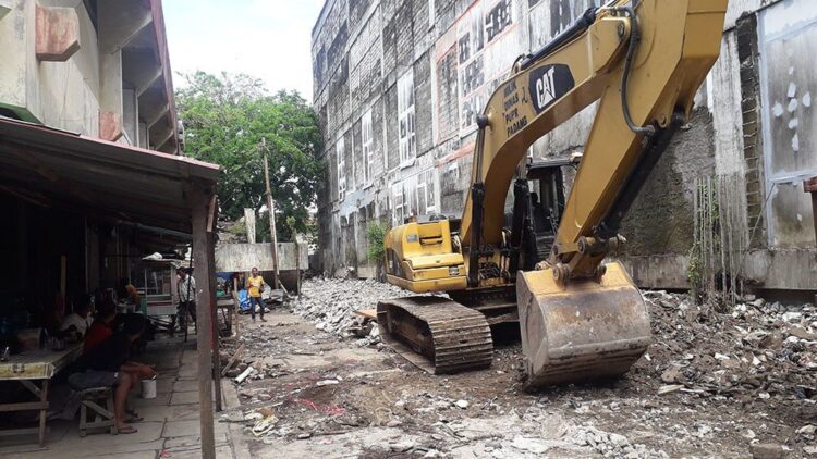 PEMBERSIHAN PUING— Satu unit alat berat diturunkan untuk membersihkan puing-puing dan material sisa gempa 2009 lalu yang sudah bertahun-tahun dibiarkan, Kamis (23/12) lalu mulai dibersihkan.