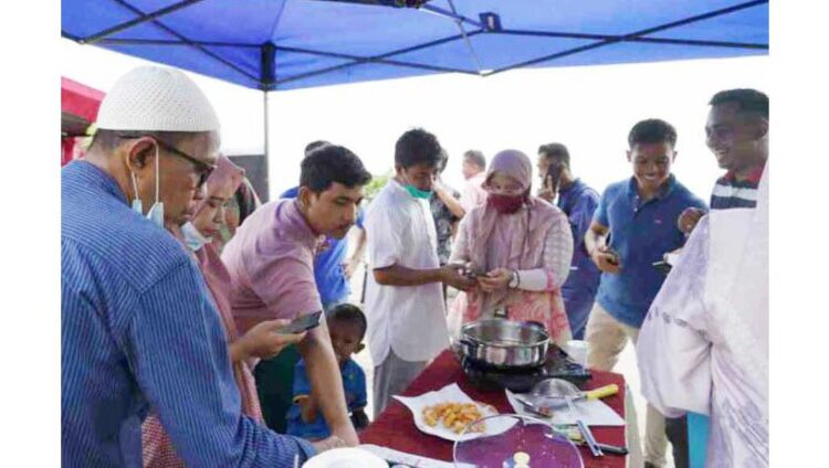 SOSIALISASI—PLN Sumbar menyosialisasikan kompor induksi kepada masyarakat yang menghadiri pembukaan Festival Tolak Bala di Pantai Ma’ruf Amin Desa Taluk Pariaman.