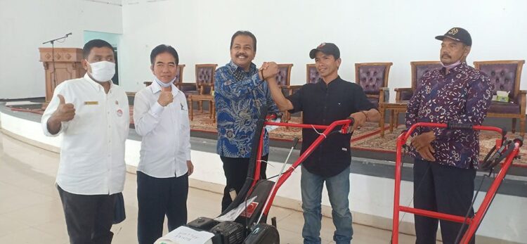 BANTUAN ALSINTA--Arkadius Dt Intan Bano salam komando dengan kelompok tani penerima bantuan alsintan.