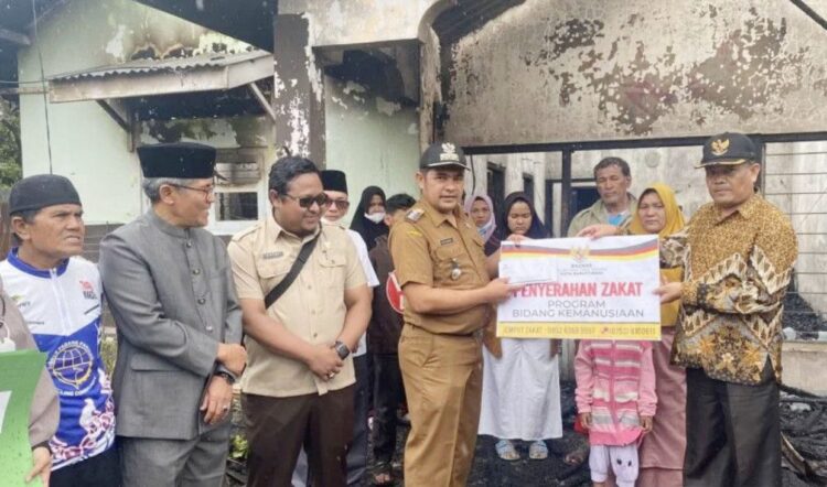 SERAHKAN--Walikota Bukittinggi melalui Camat Mandiangin Koto Selayan, Mihandrik menyerahkan bantuan kepada warga Panorama Baru yang menjadi korban musibah kebakaran.