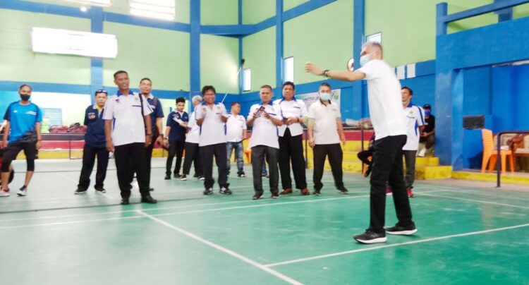 SERVICE— Ketum Pengprov PBSI Sumbar Alfiadi melakukan service perdana saat membuka pertandingan Cabor Bulutangkis Porkota Padang 2021.