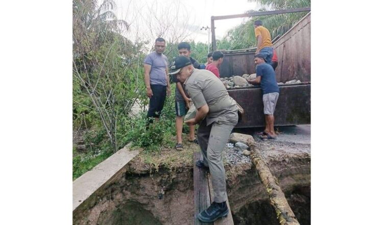 Jembatan Ujung Karang, Jorong Labuhan, Nagari Tiku V Jorong Kecamatan Tanjung Mutiara, rusak akibat diterjang banjir beberapa hari lalu, Selasa (21/12).