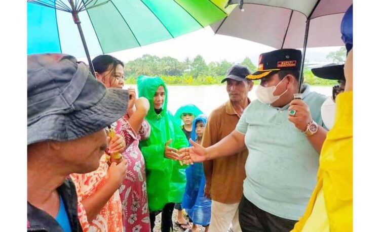 TEMUI KORBAN BANJIR—Bupati Padangapriaman Suhatri Bur temui warga yang terkena musibah banjir untuk mengingatkan kewaspadaan.