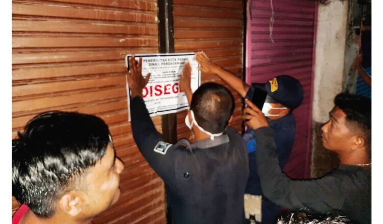 PENYEGELAN TOKO— Sejumlah toko di Pasar Alai, Pasar Tanah Kongsi, Pasar Lubuk Buaya, Pasar Ulak Karang dan pasar-pasar satelit di Kota Padang disegel tim Disdag Kota Padang. Penyegelan dilakukan karena penunggakan retrtibusi dan sudah dilayangkan Surat Peringatan l, 2 dan 3 tapi tidak diindahkan pemilik toko. Ada sekitar 27 petak toko yang disegel petugas.