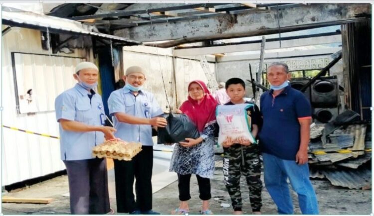 BANTUAN SEMBAKO— Kepala Pelaksana Harian UPZ Baznas Semen Padang Muhammad Arif (dua dari kiri) menyalurkan bantuan sembako untuk korban kebakaran di Indarung pada akhir November 2021. Bantuan sembako tersebut merupakan bagian dari program Peduli Kemanusiaan UPZ Baznas Semen Padang.