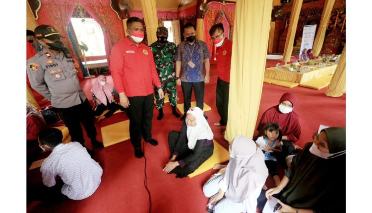 SAKSIKAN— Kepala BINDA Sumbar Hendra bersama Daulat Yang Dipertuan Rajo Alam Pagaruyuang Darul Qoror Sultan Farid Thaib Yang Dipertuan Abdul Fatah Istano Silinduang Bulan saat menyaksikan vaksinasi di Nagari Pagaruyuang, Kecamatan Tanjung Emas, Kabupaten Tanah Datar, Kamis (16/12).